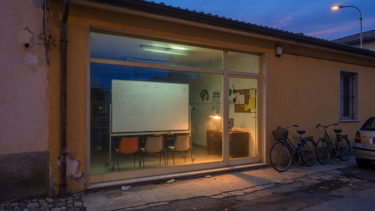Vetrina illuminata di una autoscuola di provincia all'imbrunire